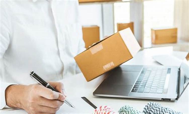 Persona sosteniendo una caja pequeña, con su mano derecha sostiene un lapiz simulando escribir algo en un papel.